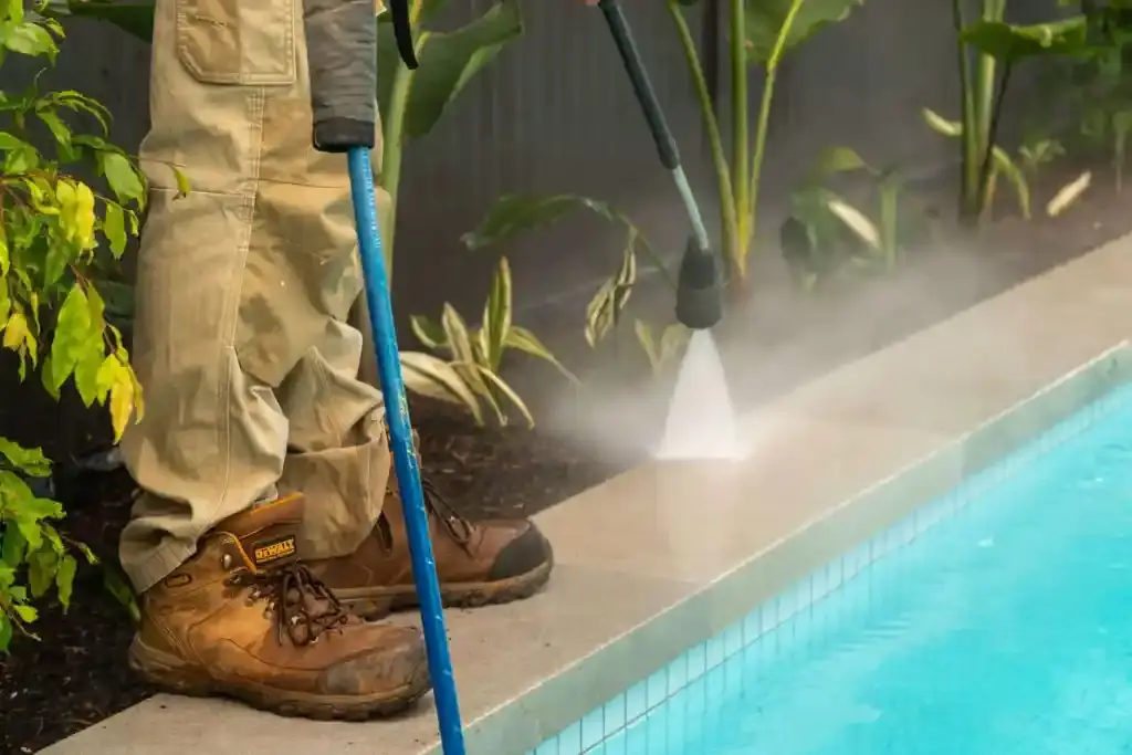 Pressure washing concrete driveways to remove dirt and debris