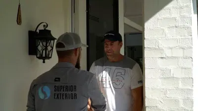 Superior Exterior expert discussing paver sealing services with a customer, showcasing professionalism and customer care.