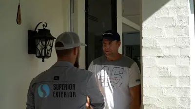 Superior Exterior expert discussing paver sealing services with a customer, showcasing professionalism and customer care.